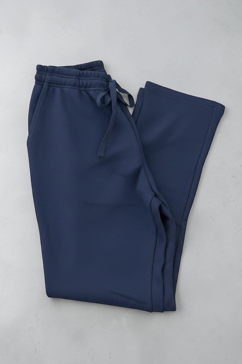 Pair of navy blue track pants on a white background