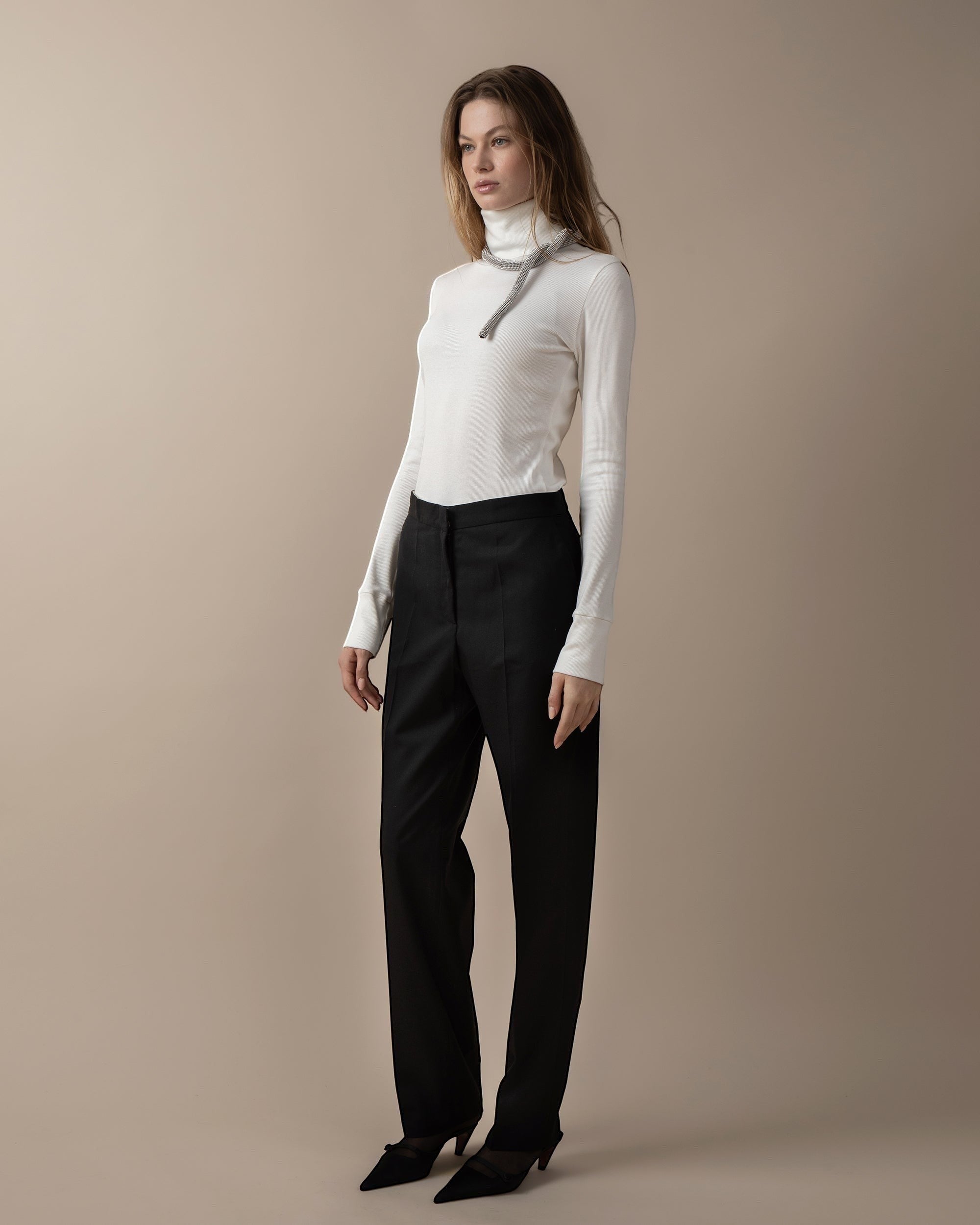 Maison Sarava women's black high-waist straight-fit trousers with front patch pockets and A-design stitching detail below the knee.