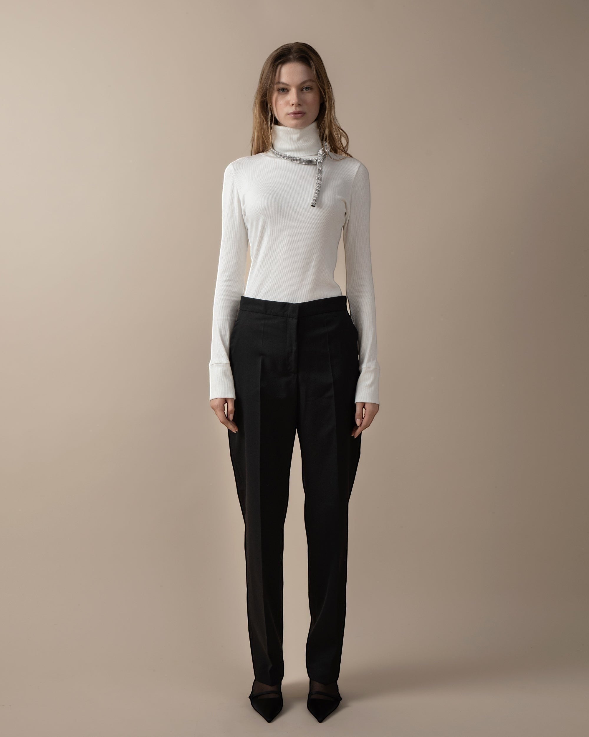 Maison Sarava women's black high-waist trousers with straight fit, two front patch pockets, and A-design stitching on back pockets. Cut detail below the knee.