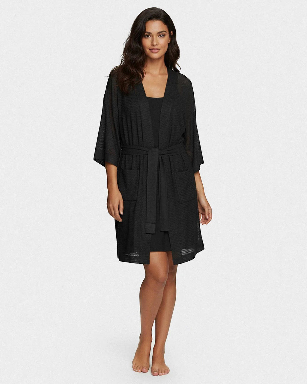 Maison Sarava black waffle knit kimono robe with wide sleeves, self-tie belt, and pockets, worn by a model.