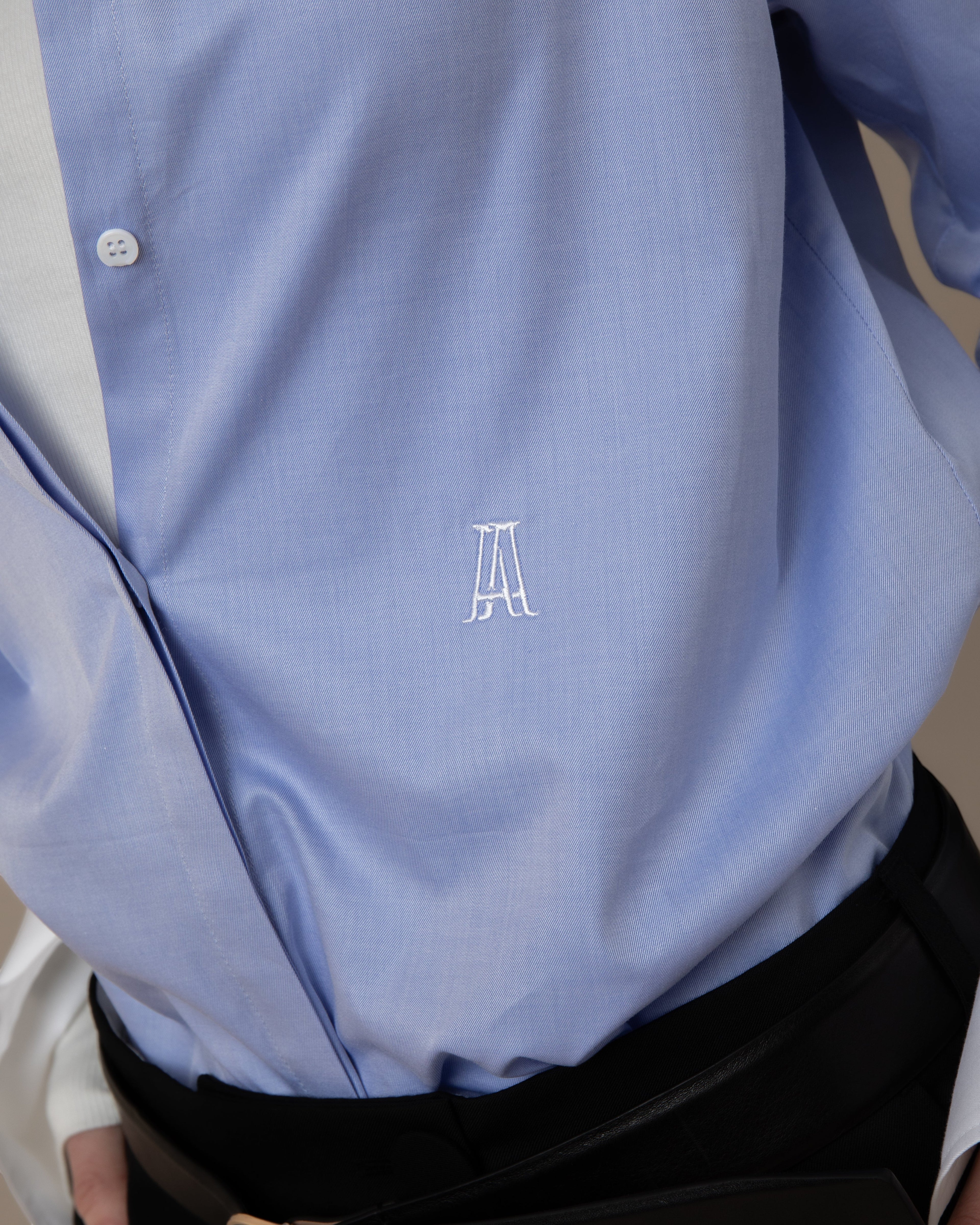 Maison Sarava light blue fitted shirt with pointed collar, hidden buttons, and embroidered logo.