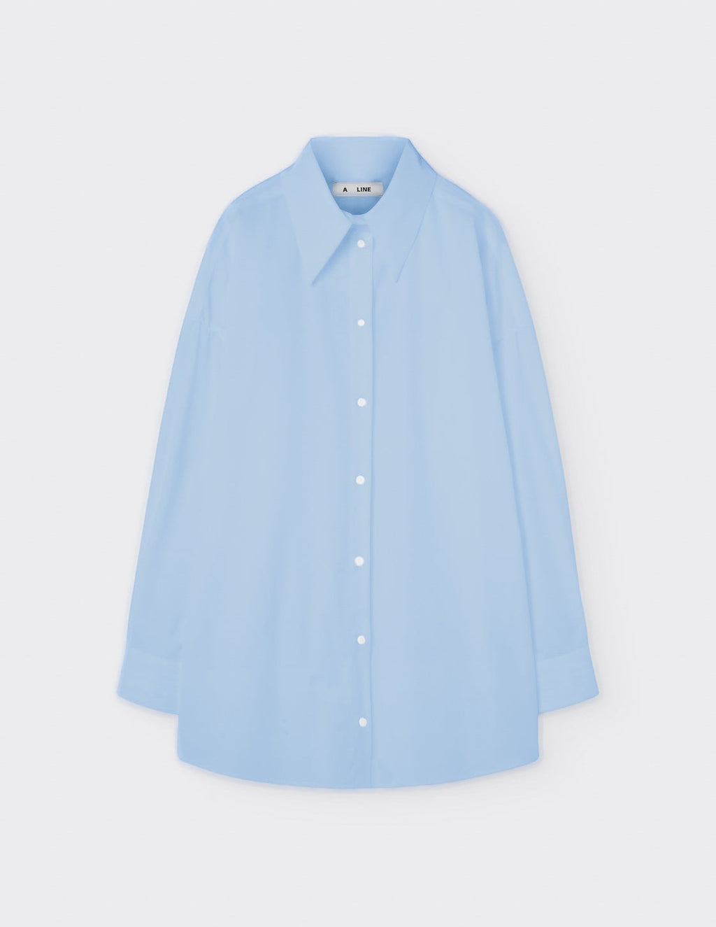 Maison Sarava light blue oversized cotton shirt with pointed collar, dropped shoulders, and double-pleat cuffs.
