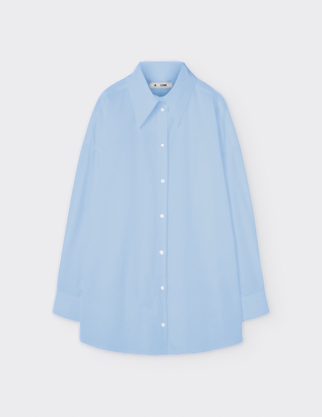 Maison Sarava light blue oversized cotton shirt with pointed collar, dropped shoulders, and double-pleat cuffs.