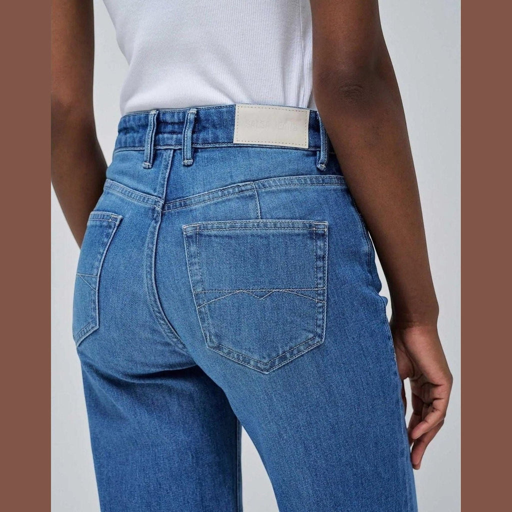 Maison Sarava women's straight leg blue denim jeans with five pockets and a white leather patch.