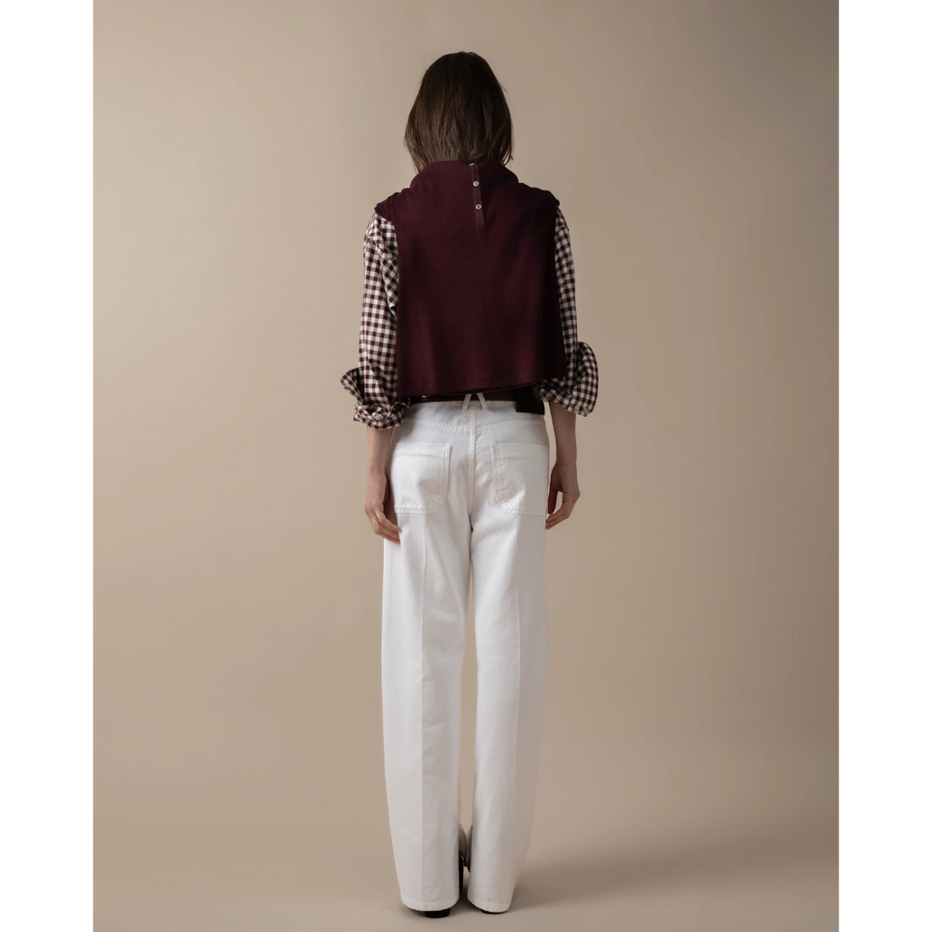 Maison Sarava women's oversized burgundy western shirt with pointed collar and buttoned front, paired with a gingham shirt and white jeans.