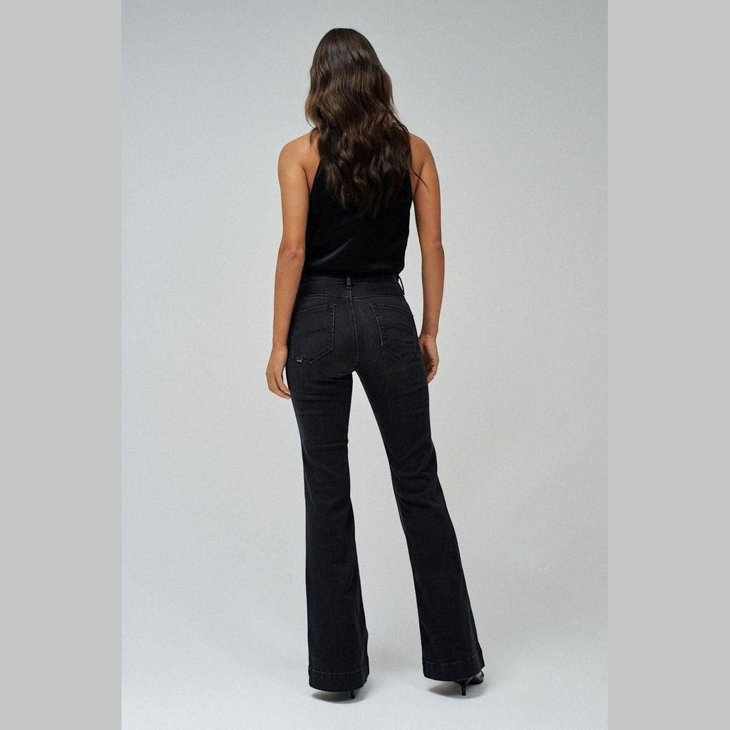 Maison Sarava charcoal wash high waisted flare denim jeans worn by a model from behind.