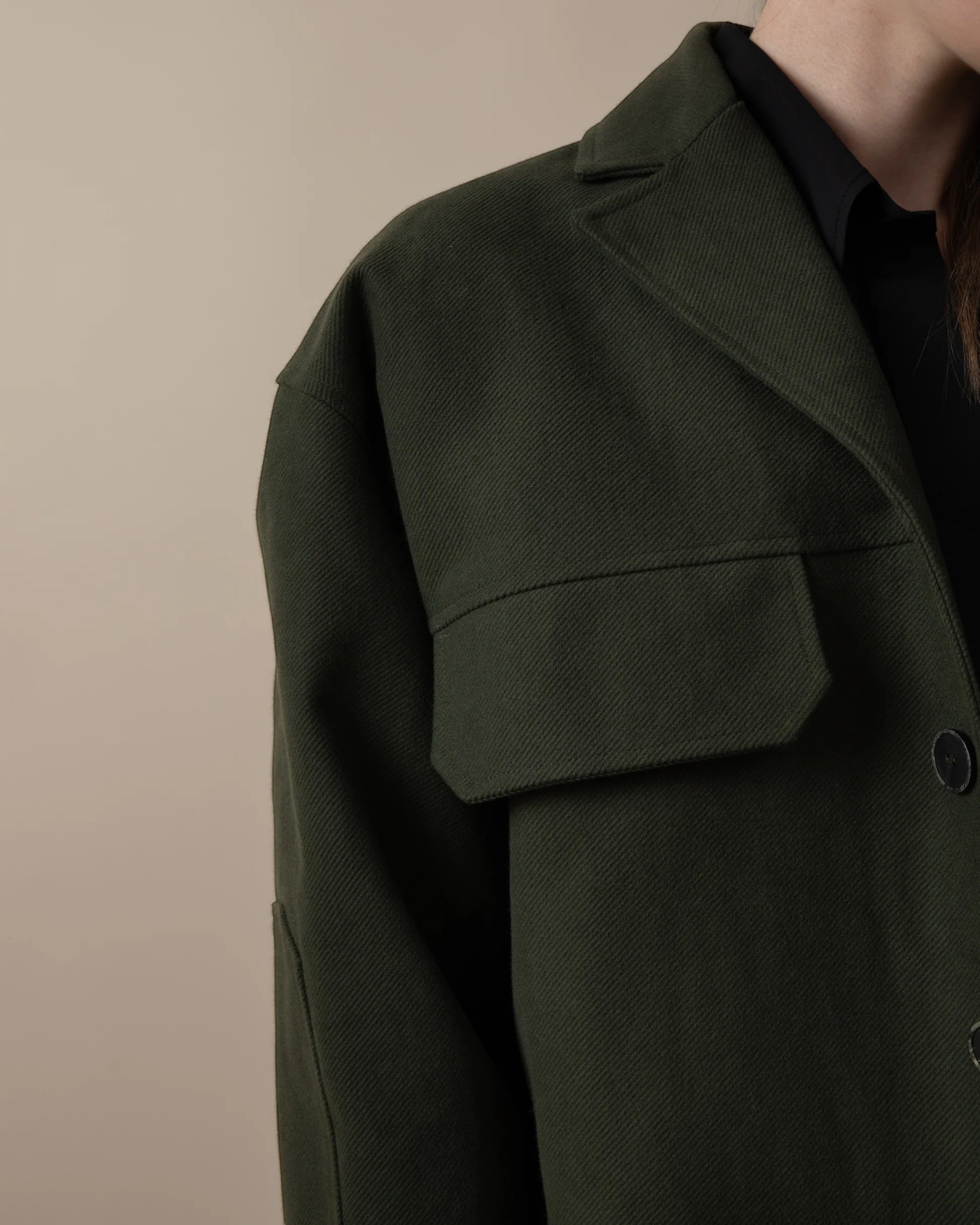 Maison Sarava dark green oversized utility jacket with peaked lapels, patch pockets, and elbow patches.