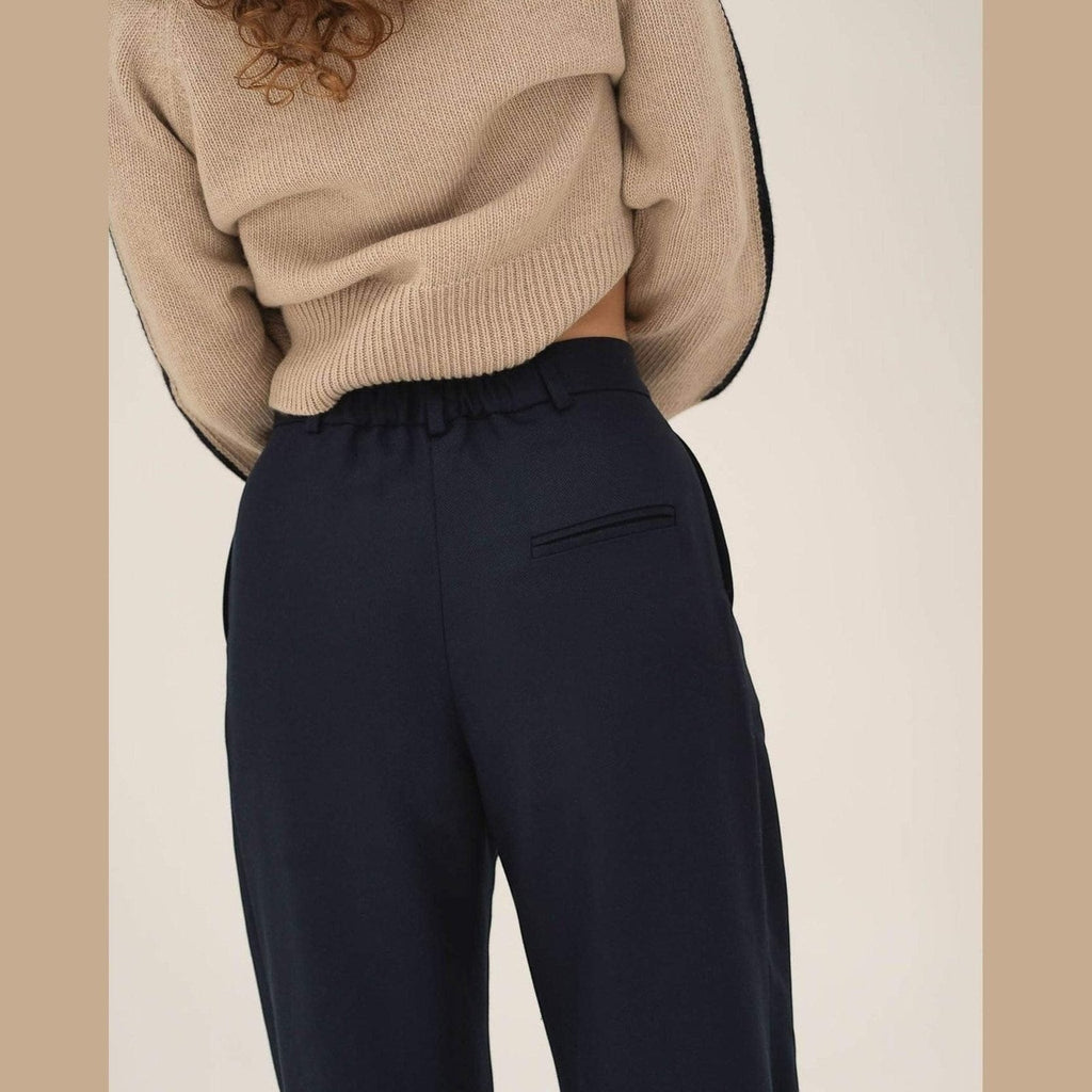 Maison Sarava navy wide leg pleated trousers with a comfortable elastic waistband and back pocket detail.