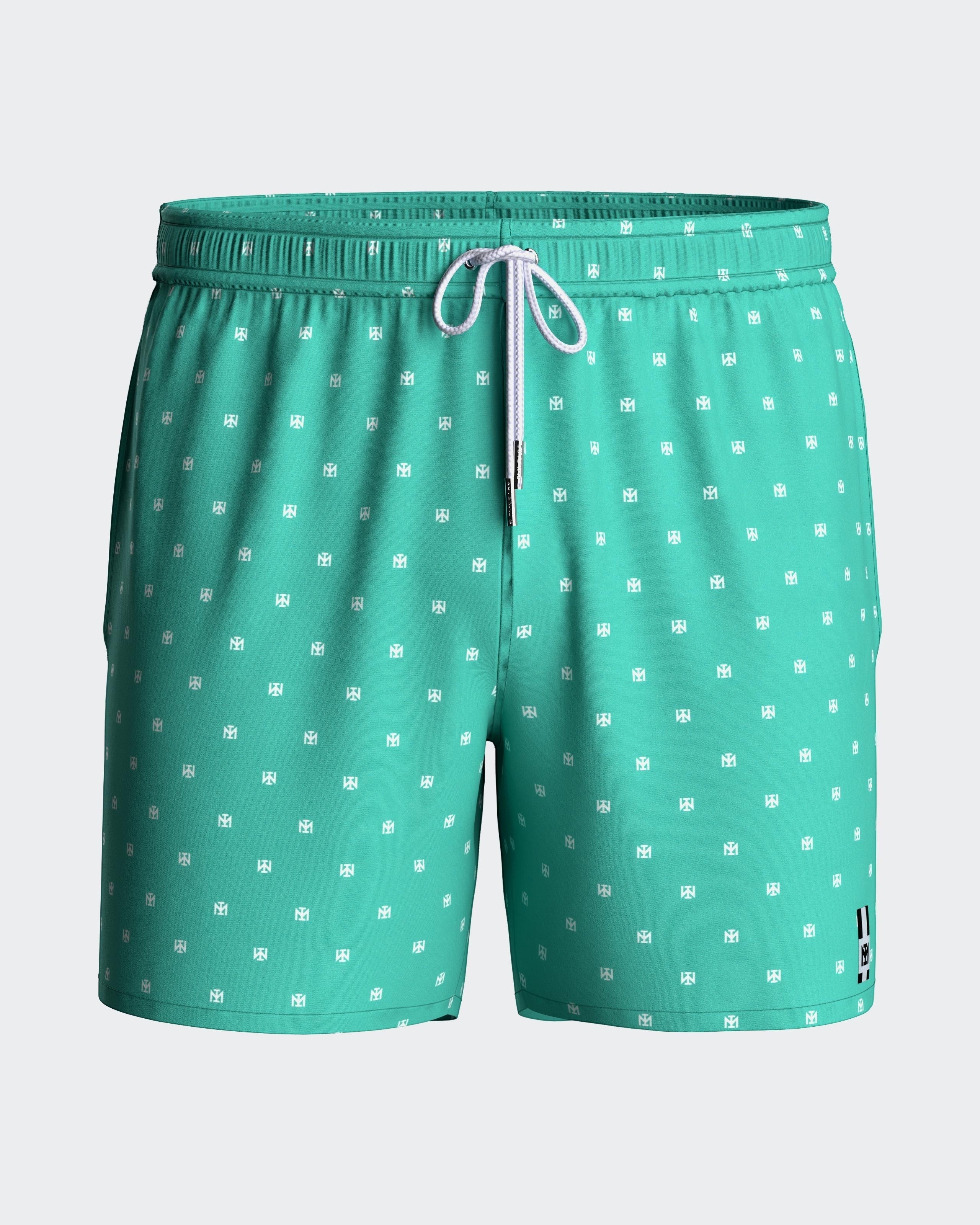 Maison Sarava men's teal swim trunks with white micro-pattern logo, drawstring waist, side pockets, and inner mesh lining.