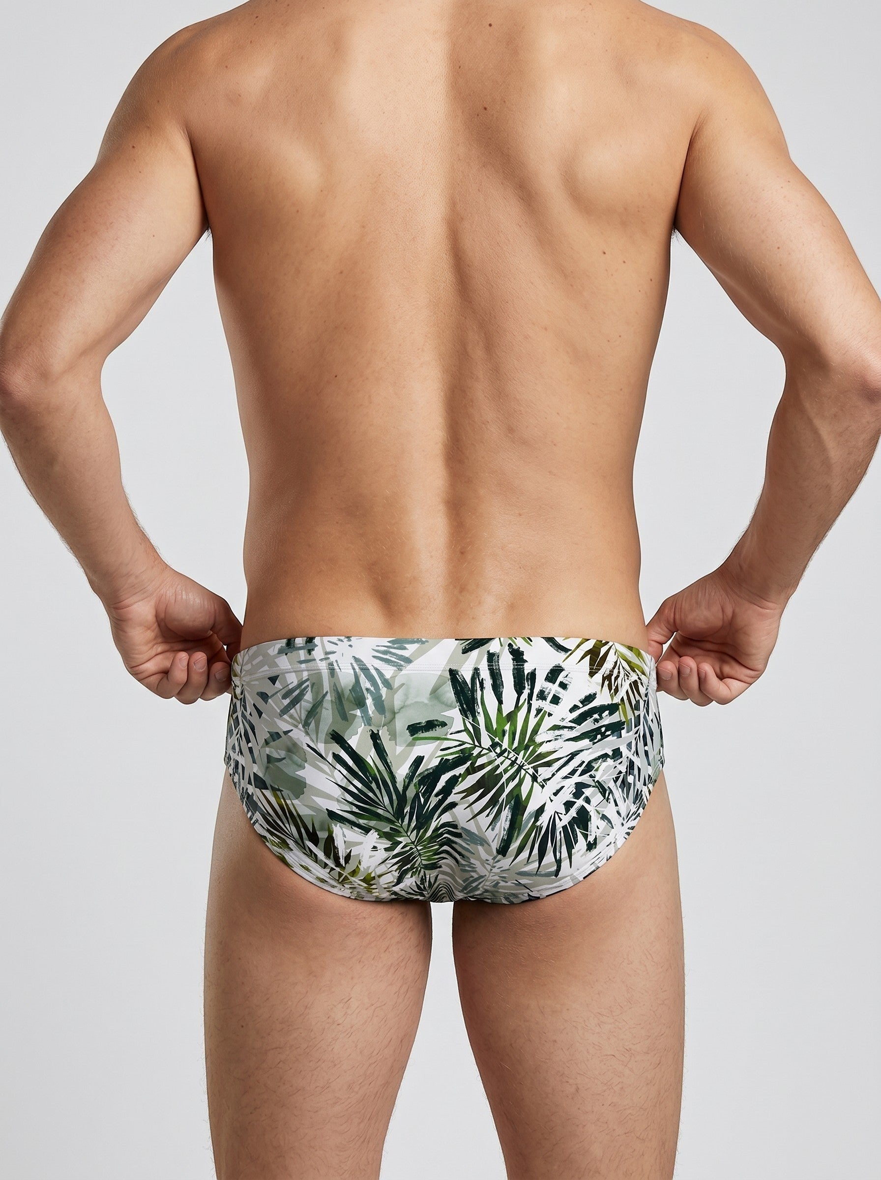 Maison Sarava men's tropical leaf print swim briefs in green and white. Form-fitting, quick-drying fabric.