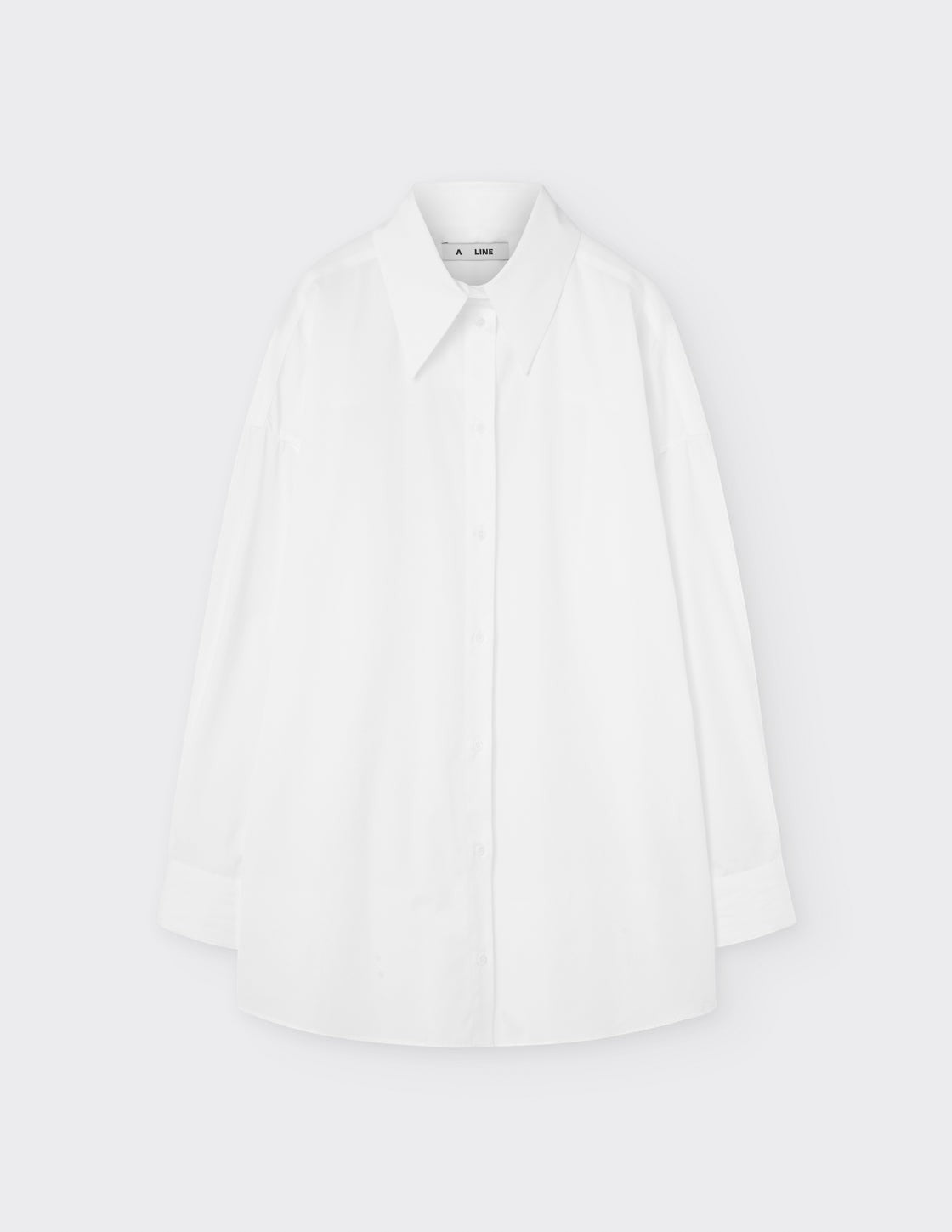 Maison Sarava white cotton oversized shirt with pointed collar, dropped shoulders, and double-pleat cuffs.