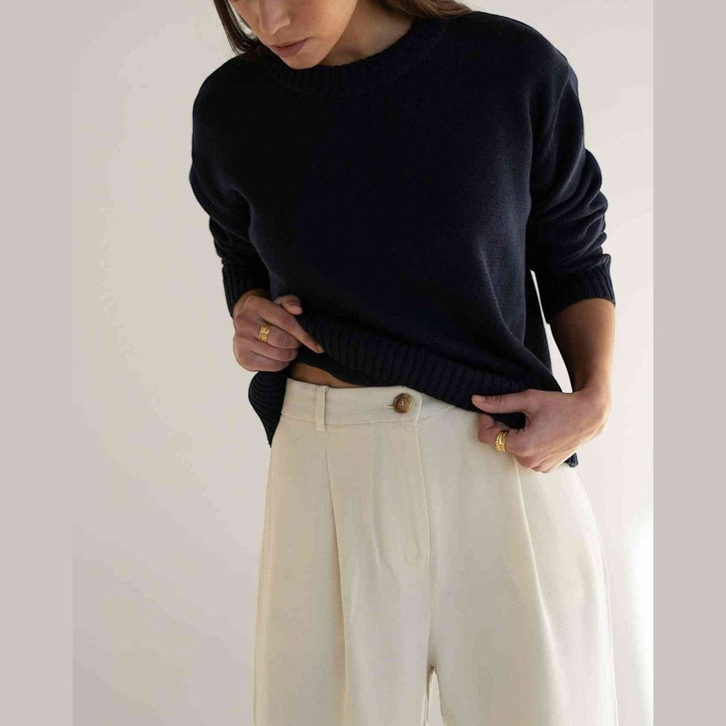 Maison Sarava white tencel wide-leg trousers with front pleats and elastic waistband.